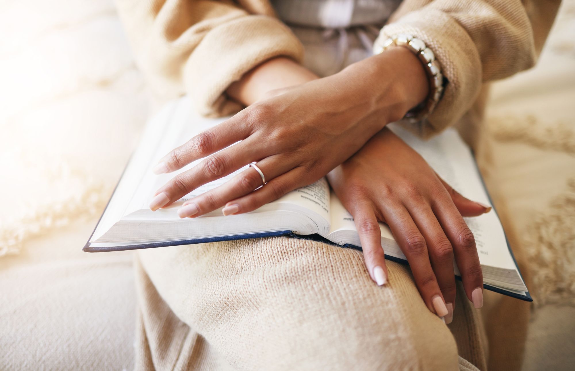 Hands at rest on an open Bible